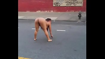 una mujer drogada desnuda detenida rodando en el suelo